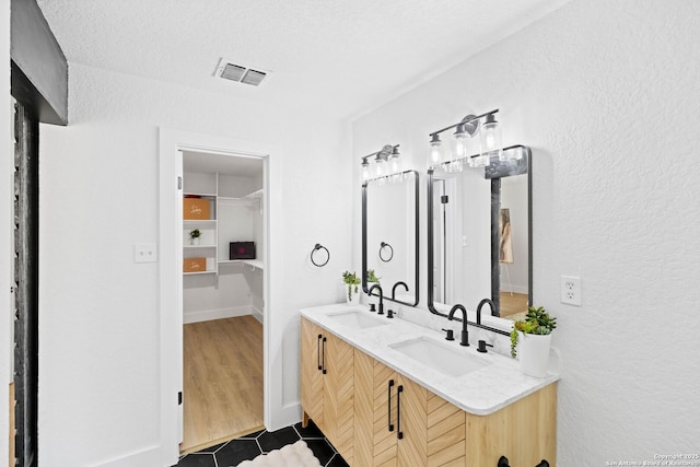 bathroom featuring vanity, tile patterned floors, and a textured ceiling