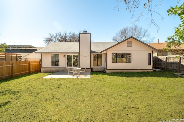 back of house with a patio area and a lawn