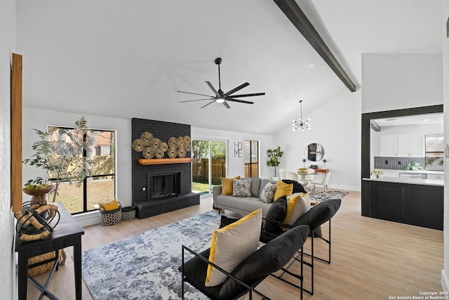 living room with vaulted ceiling with beams, a fireplace, light hardwood / wood-style flooring, and ceiling fan with notable chandelier