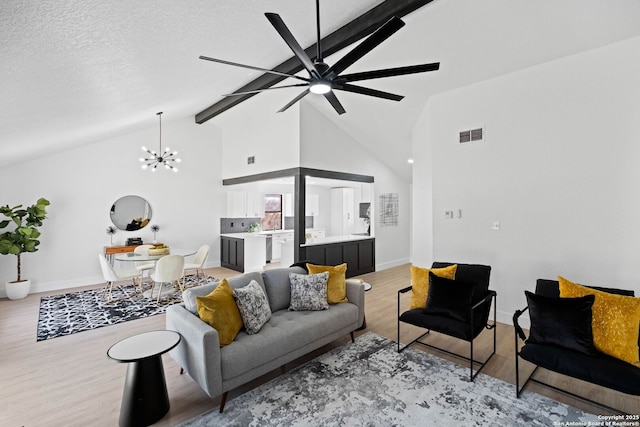 living room with hardwood / wood-style flooring, a textured ceiling, ceiling fan with notable chandelier, and vaulted ceiling with beams