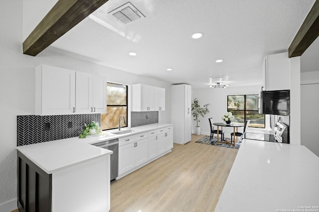 kitchen featuring dishwasher, white cabinetry, tasteful backsplash, sink, and stove