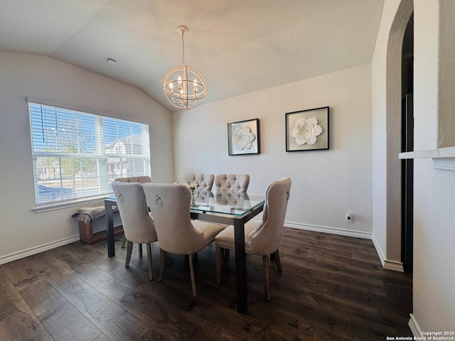 dining area with vaulted ceiling, dark wood-type flooring, and a notable chandelier