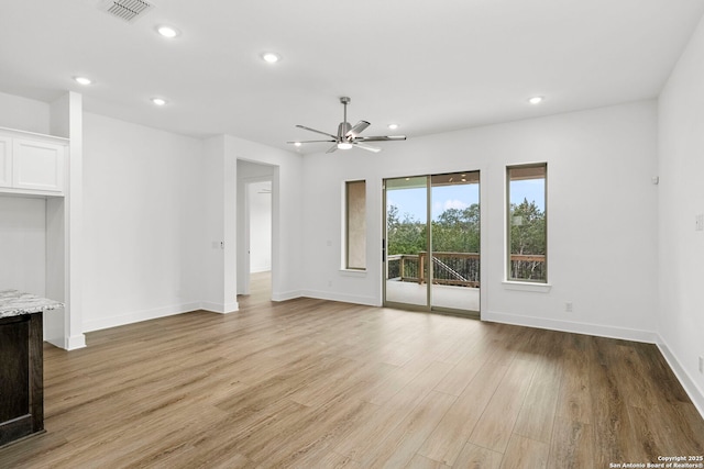 unfurnished living room with ceiling fan and light wood-type flooring