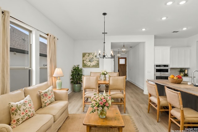 living room featuring an inviting chandelier and light hardwood / wood-style floors