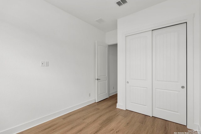 unfurnished bedroom with a closet and light wood-type flooring