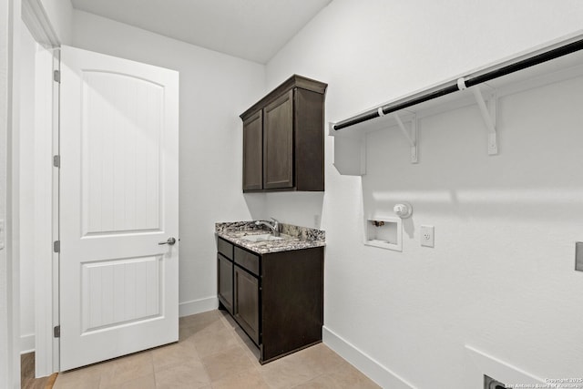 laundry area with hookup for a gas dryer, sink, hookup for a washing machine, light tile patterned floors, and cabinets