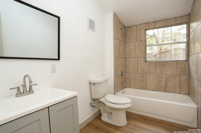 full bathroom featuring toilet, vanity, tiled shower / bath, and hardwood / wood-style floors