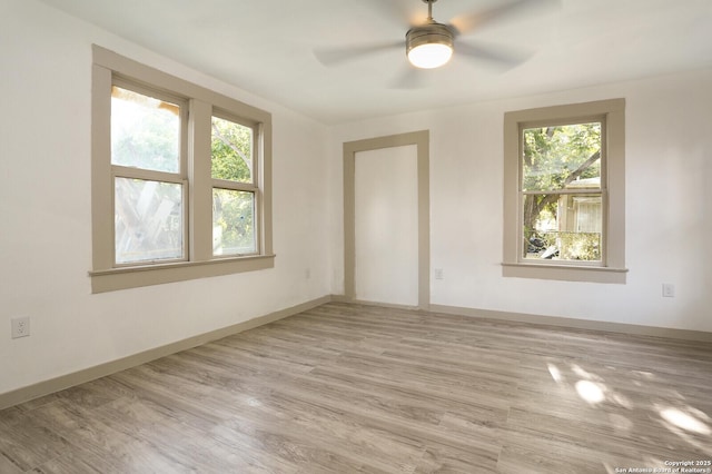 spare room with ceiling fan, a healthy amount of sunlight, and light hardwood / wood-style flooring