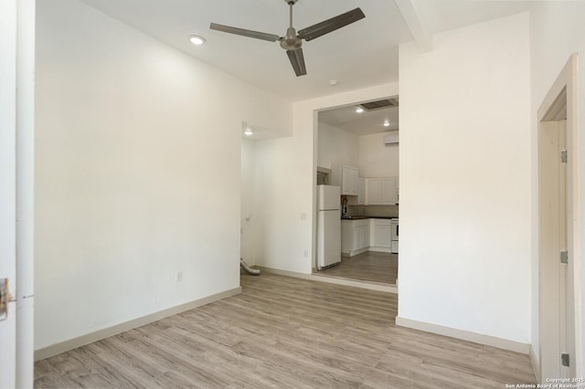 unfurnished room featuring ceiling fan, beam ceiling, and light wood-type flooring