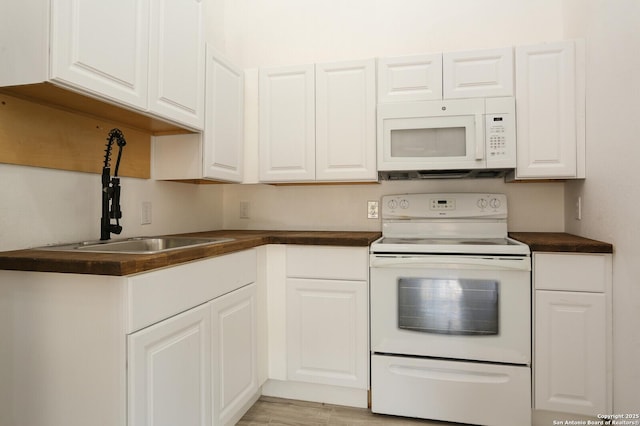 kitchen with sink, white cabinets, and white appliances