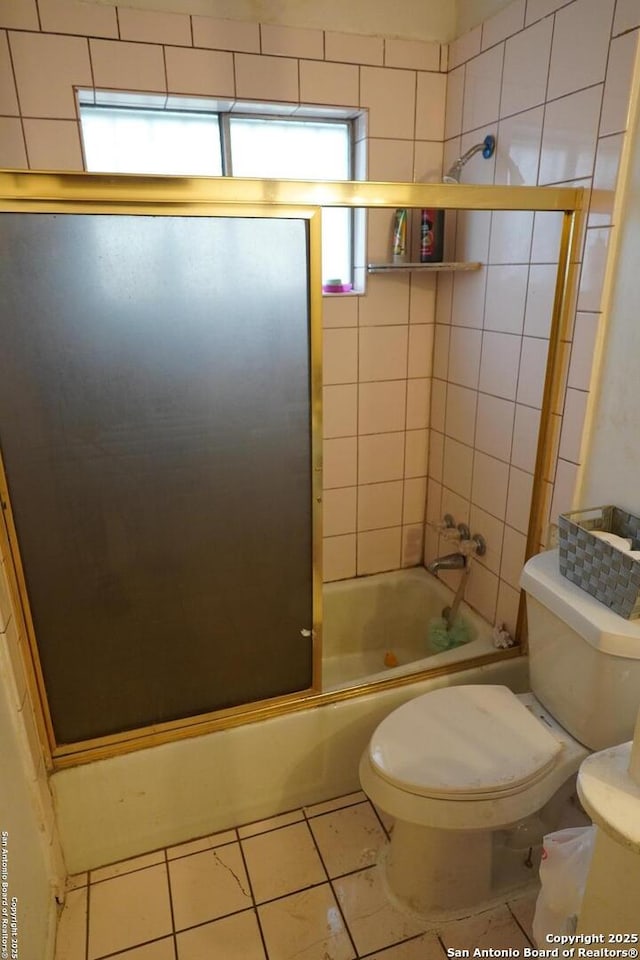 bathroom with enclosed tub / shower combo, toilet, and tile patterned flooring