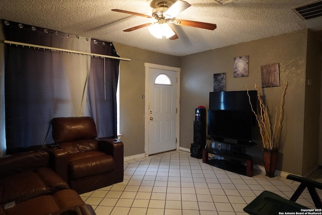 living room featuring ceiling fan, light tile patterned floors, and a textured ceiling