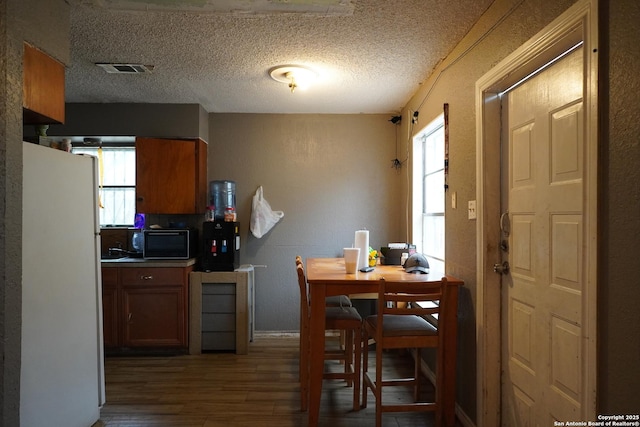 kitchen featuring white fridge, dark wood-type flooring, and a textured ceiling