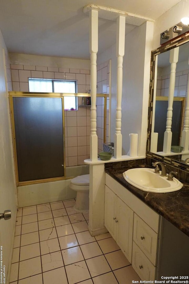 full bathroom featuring toilet, tile patterned floors, vanity, and shower / bath combination with glass door