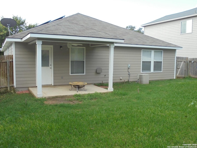 back of property with a patio, central AC unit, a fire pit, and a lawn