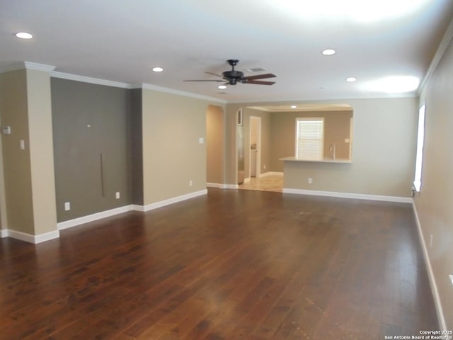 spare room with dark wood-type flooring, crown molding, and ceiling fan