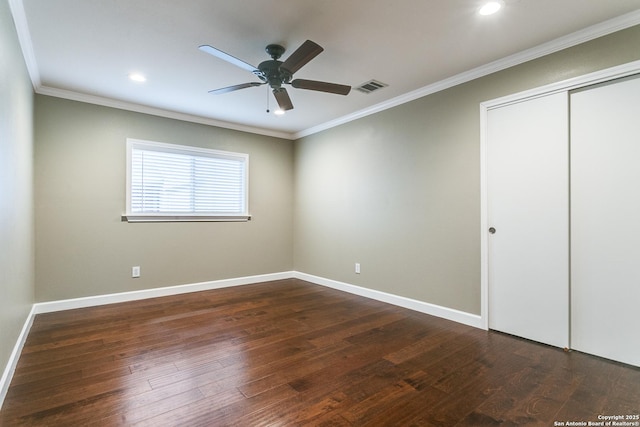 unfurnished bedroom featuring crown molding, dark wood-type flooring, ceiling fan, and a closet