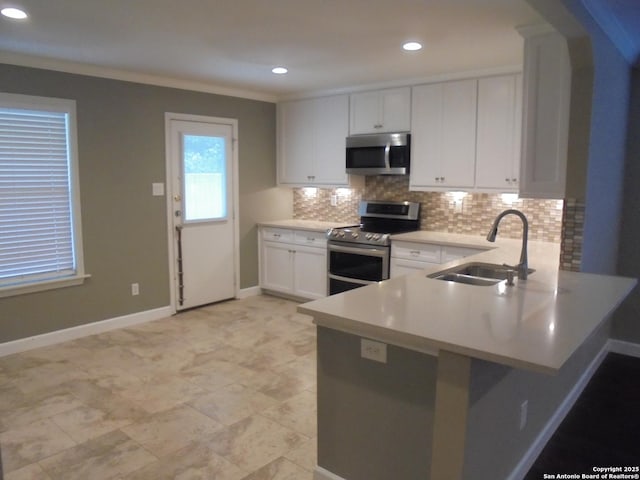 kitchen featuring sink, appliances with stainless steel finishes, white cabinets, decorative backsplash, and kitchen peninsula