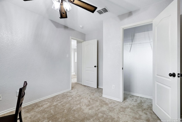 unfurnished bedroom featuring ceiling fan, a closet, and light colored carpet