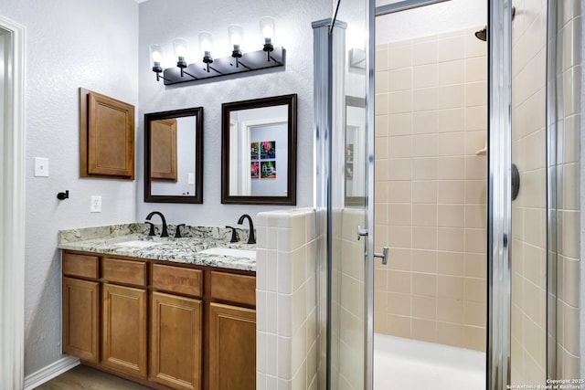 bathroom featuring a shower with shower door and vanity