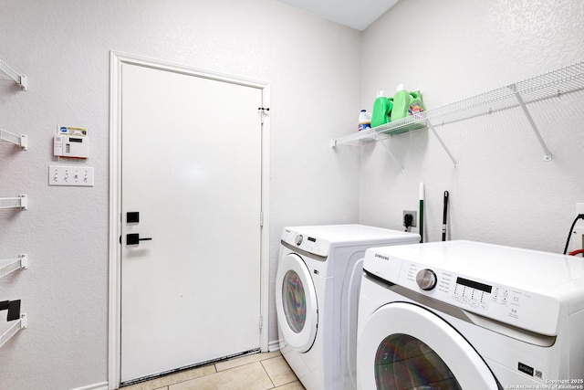 laundry room with washer and clothes dryer and light tile patterned floors