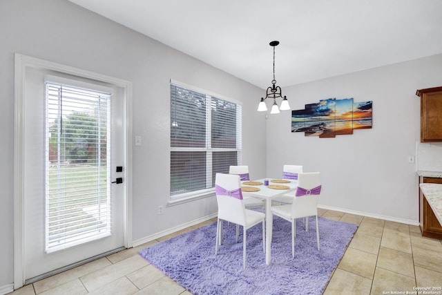 tiled dining room featuring a chandelier