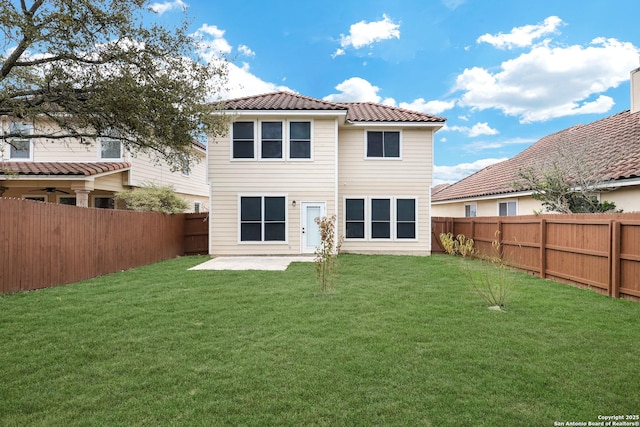 rear view of property featuring a lawn and a patio