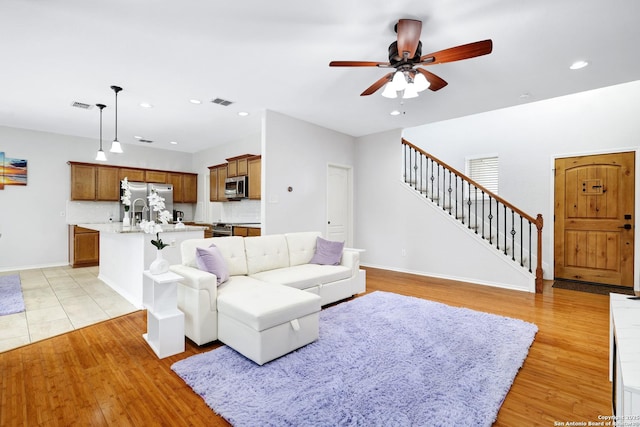 living room with light wood-type flooring and ceiling fan