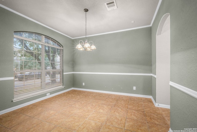 tiled spare room featuring a chandelier and ornamental molding