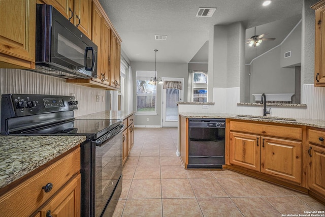 kitchen featuring black appliances, light stone countertops, sink, and a textured ceiling