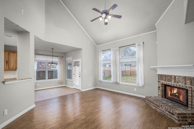 unfurnished living room featuring ceiling fan, light hardwood / wood-style flooring, crown molding, and a fireplace