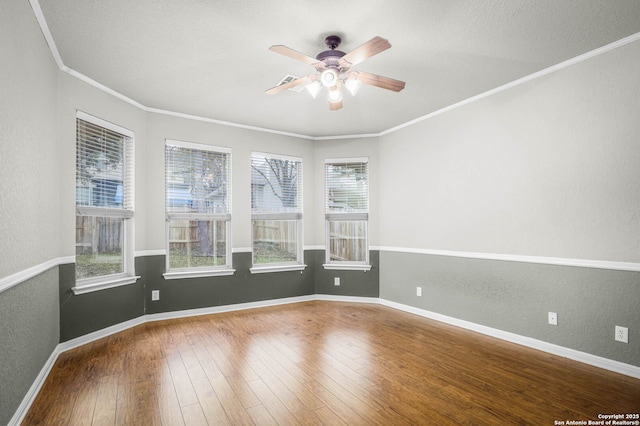 unfurnished room with ceiling fan, a wealth of natural light, crown molding, and hardwood / wood-style floors