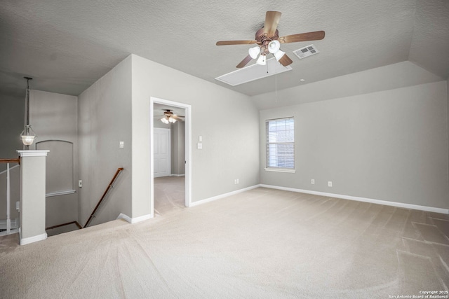 empty room with vaulted ceiling, carpet, and a textured ceiling