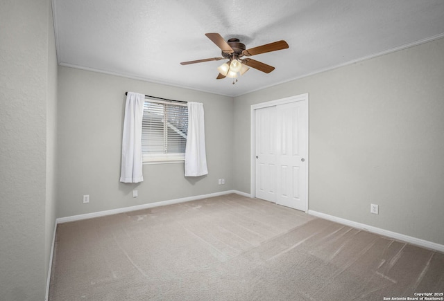 interior space with ceiling fan, ornamental molding, and carpet floors