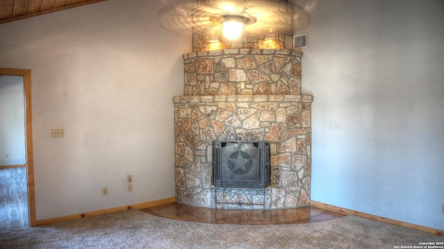 unfurnished living room featuring carpet floors and a stone fireplace