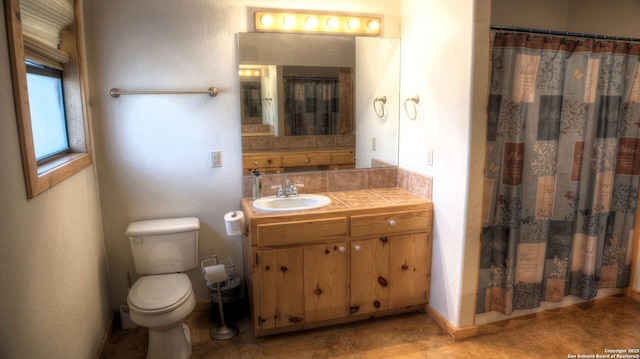 bathroom with toilet, walk in shower, and vanity