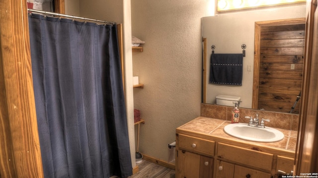 bathroom with hardwood / wood-style flooring, toilet, and vanity