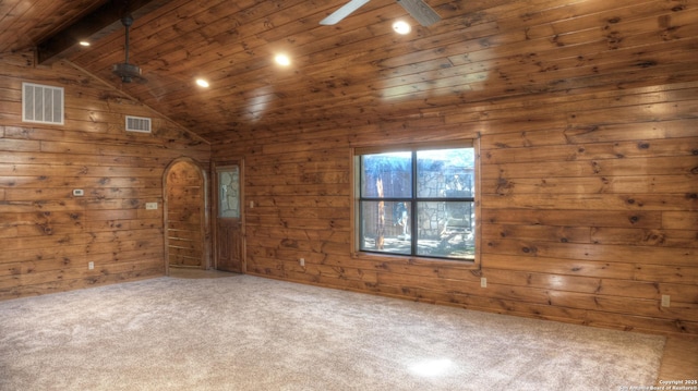 spare room featuring wood ceiling, wood walls, ceiling fan, carpet floors, and vaulted ceiling with beams