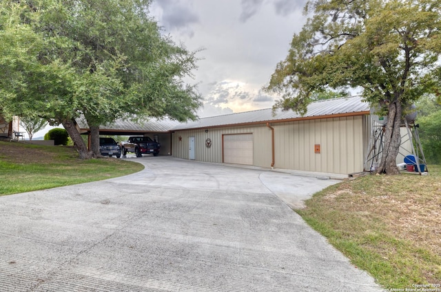 view of front of home with a garage, a front yard, and a carport