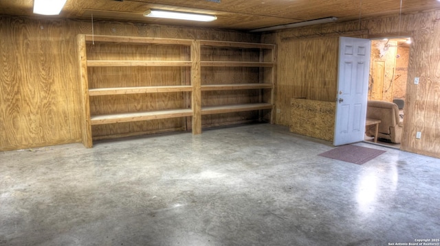 basement featuring wooden walls