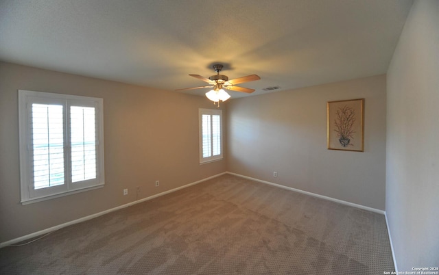 carpeted spare room with ceiling fan