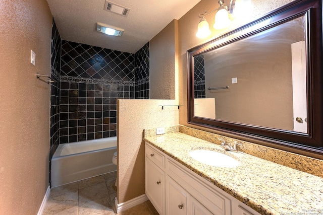 full bathroom with toilet, tiled shower / bath, tile patterned floors, a textured ceiling, and vanity