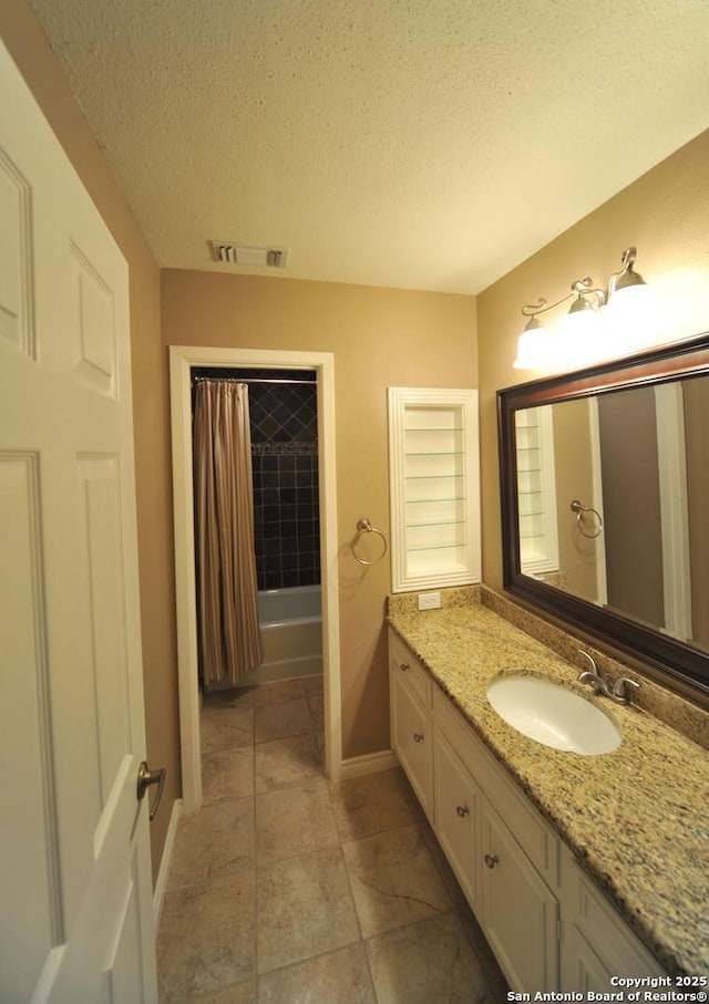 bathroom featuring vanity, shower / bath combination with curtain, and a textured ceiling