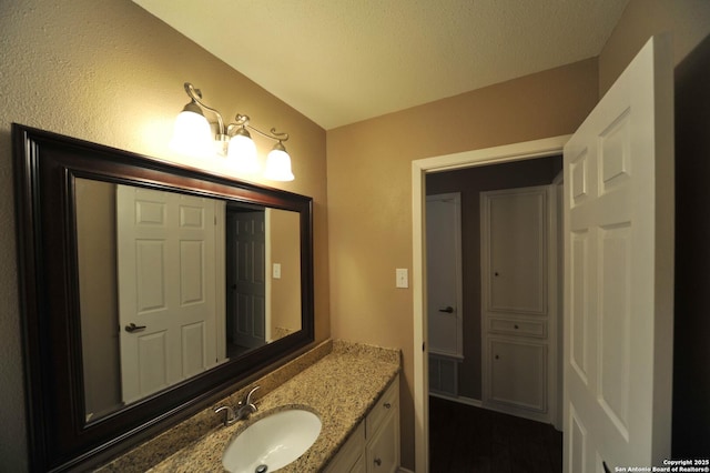 bathroom with a textured ceiling and vanity