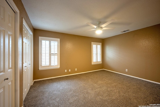 spare room with carpet floors, a healthy amount of sunlight, ceiling fan, and a textured ceiling