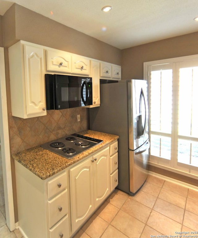 kitchen featuring white cabinets, decorative backsplash, dark stone countertops, and stovetop