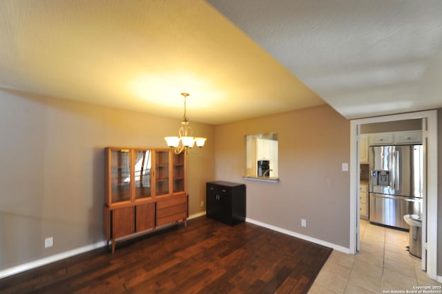 unfurnished dining area with a notable chandelier and a textured ceiling