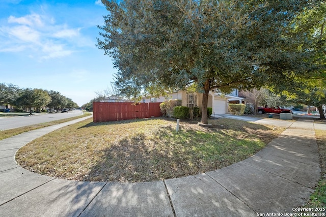 view of property hidden behind natural elements featuring a garage