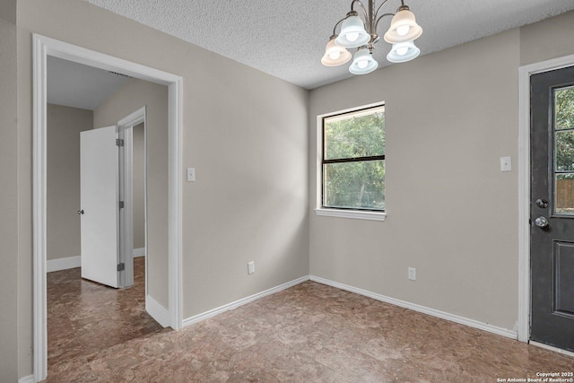 empty room with a textured ceiling and a notable chandelier