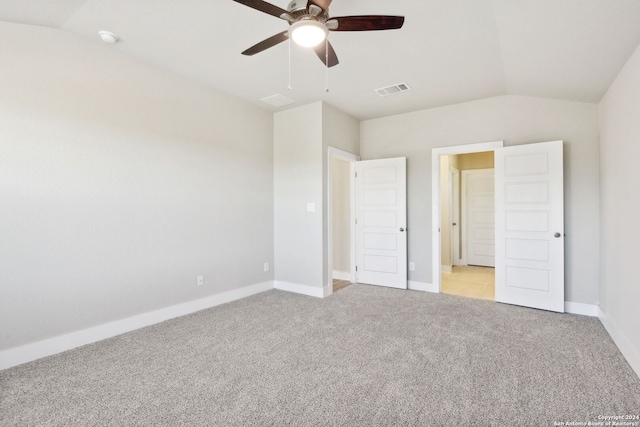 unfurnished bedroom with ceiling fan, vaulted ceiling, and light carpet